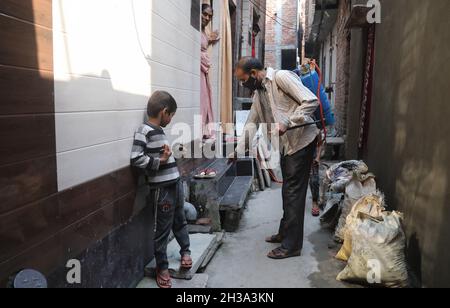 Neu-Delhi, Indien. Oktober 2021. Ein Arbeiter desinfiziert ein Wohngebiet als Vorsichtsmaßnahme gegen die Ausbreitung der Dengue-Krankheit im Rahmen der Vernebelungskampagne in Shalimar Bagh. In Delhi werden 1,006 Dengue-Fälle gemeldet, 154 Fälle von Malaria und 73 Fälle von Chikungunya, wie aus den Daten der South Delhi Municipal Corporation bekannt gegeben. Kredit: SOPA Images Limited/Alamy Live Nachrichten Stockfoto