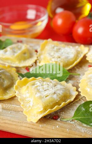 Konzept des Kochens von Ravioli auf rotem Hintergrund Stockfoto