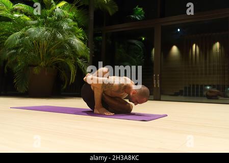 Omar Mura Mann mittleren Alters kaukasischen führt eine Yoga-Position in Innenräumen. Stockfoto