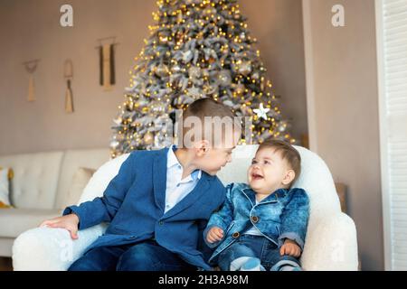 Glücklich lachende kleine Kinder. Liebevolle Brüder in guter Stimmung freuen sich auf Weihnachten. Überglücklich entzückende Kinder, die Spaß in den Winterferien ne Stockfoto