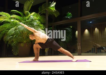 Omar Mura Mann mittleren Alters kaukasischen führt eine Yoga-Position in Innenräumen. Stockfoto