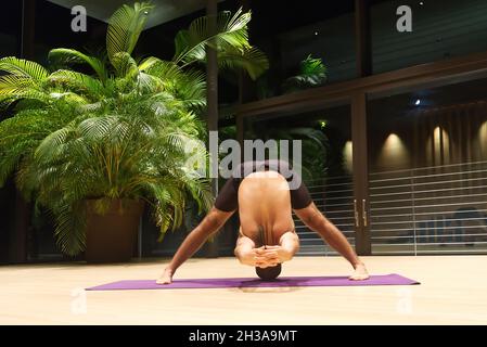 Omar Mura Mann mittleren Alters kaukasischen führt eine Yoga-Position in Innenräumen. Stockfoto