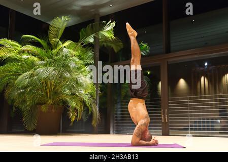 Omar Mura Mann mittleren Alters kaukasischen führt eine Yoga-Position in Innenräumen. Stockfoto