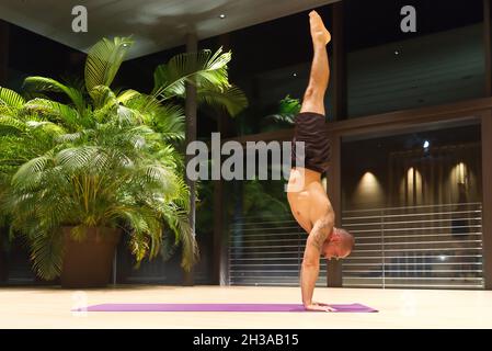 Omar Mura Mann mittleren Alters kaukasischen führt eine Yoga-Position in Innenräumen. Stockfoto