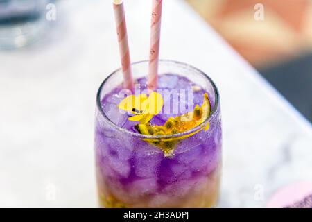 Ombre Passion Fruit Cooler mit Butterfly-Erbsentee, gekrönt mit essbaren Blumen im EL&N Cafe Brompton Road, London, Großbritannien Stockfoto