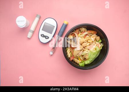 Werkzeuge zur Messung von Diabetes und Insulin-Stift und gesunde Ernährung auf Pink Stockfoto