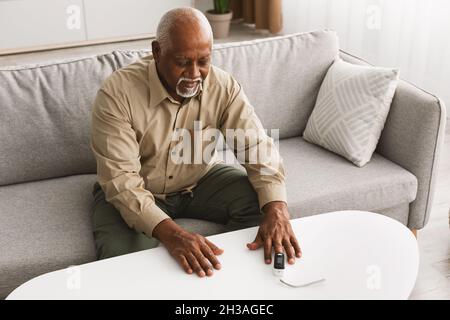 Kranker Älterer Afrikanischer Mann Mit Pulsoximeter Messung Der Sättigung In Innenräumen Stockfoto