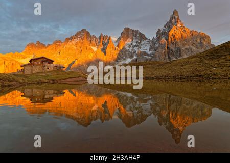 PASSO ROLLE, ITALIEN, 19. Oktober 2021 : Pale di San Martino Gruppe, die während des Sonnenuntergangs auf einem See in den Dolomiten reflektiert. Stockfoto