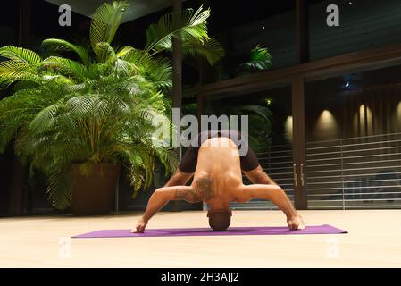 Omar Mura Mann mittleren Alters kaukasischen führt eine Yoga-Position in Innenräumen. Stockfoto