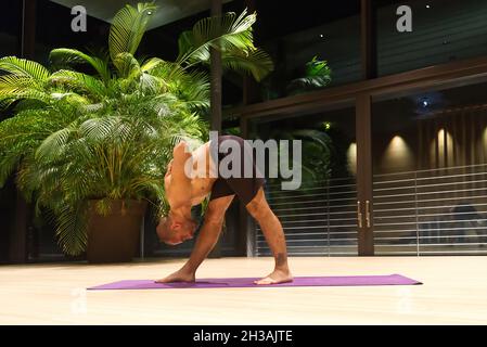 Omar Mura Mann mittleren Alters kaukasischen führt eine Yoga-Position in Innenräumen. Stockfoto