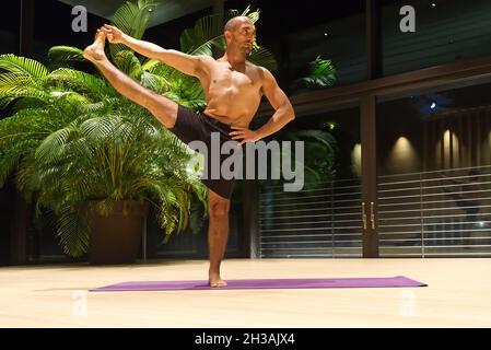 Omar Mura Mann mittleren Alters kaukasischen führt eine Yoga-Position in Innenräumen. Stockfoto