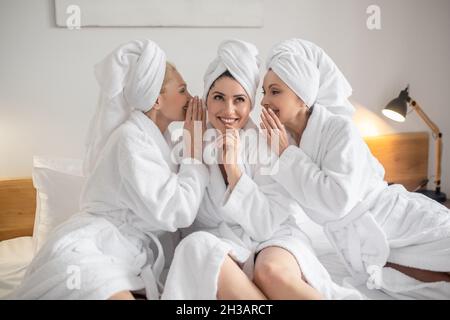 Interessierte Frau und zwei Klatschfreunde Stockfoto