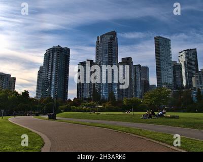 Wunderschöne Aussicht auf den David Lam Park in der Innenstadt von Vancouver am False Creek, wo die Menschen die Nachmittagssonne genießen und Hochhäuser mit Wohngebäuden. Stockfoto