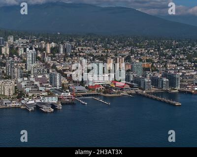 Luftaufnahme von North Vancouver mit den Werften im Bezirk Lower Lonsdale mit Küste, Wohngebäuden und Bergen im Hintergrund. Stockfoto