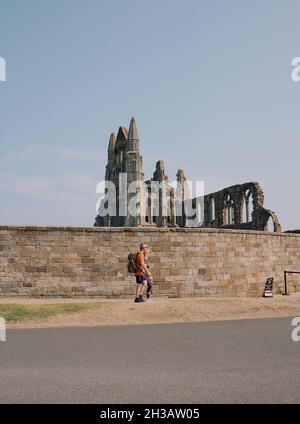 Touristen & Eintritt in die gotischen Ruinen der Whitby Abbey ein christliches Kloster aus dem 7. Jahrhundert wurde später zu einer Benediktinerabtei, die von English Heritage verwaltet wird Stockfoto