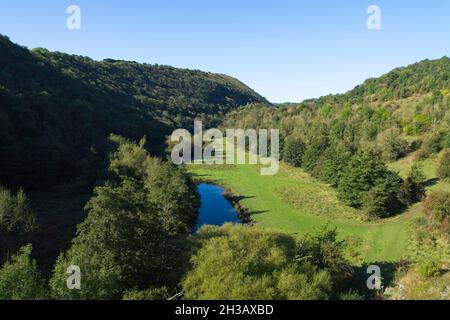 Blick über die Baumkronen hinunter das tiefe Tal von Monsal Dale in Derbyshire von oben auf dem Monsal Grabstein-Viadukt Stockfoto