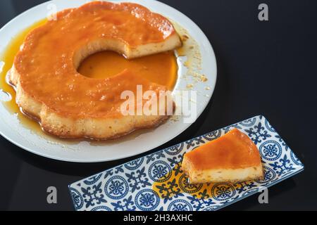 Pudding, köstliches brasilianisches Dessert aus Kondensmilch, in Stücke geschnitten, auf einem Teller. Stockfoto