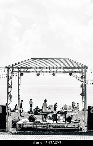 Monochrome Aufnahme einer kleinen Konzertbühne am Strand während einer Party im Sevan-See, Armenien Stockfoto