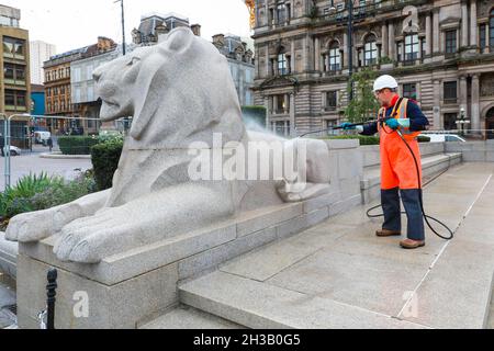 Glasgow, Großbritannien. Oktober 2021. Arbeiter reinigten das Cenotaph der Stadt und die symbolischen Löwen auf dem George Square, vor den Stadtkammern, mit Hochdruckwasserkanonen, um die jährlichen Gedenkfeiern im November vorzubereiten. Kredit: Findlay/Alamy Live Nachrichten Stockfoto