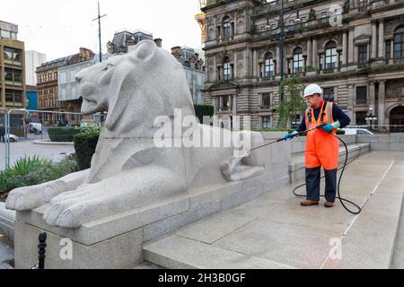 Glasgow, Großbritannien. Oktober 2021. Arbeiter reinigten das Cenotaph der Stadt und die symbolischen Löwen auf dem George Square, vor den Stadtkammern, mit Hochdruckwasserkanonen, um die jährlichen Gedenkfeiern im November vorzubereiten. Kredit: Findlay/Alamy Live Nachrichten Stockfoto