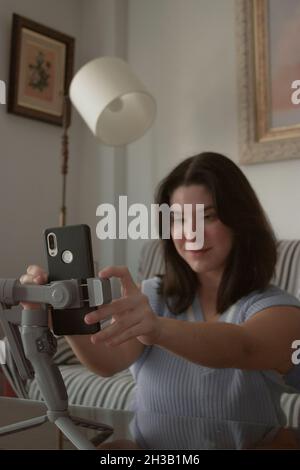 Junge Bloggerin Mädchen, das Handy auf Stativ, um tägliche Blog aufzeichnen Blick auf ihre Handy-Kamera. Online-Videoblog für soziale Medien. Stockfoto