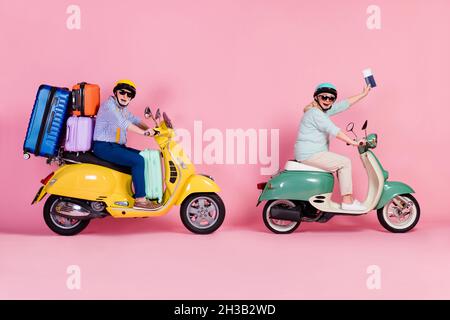 Profil Seite Foto von älteren Mann Frau fahren Motorrad Helme halten Pass Gepäck isoliert rosa Hintergrund Stockfoto