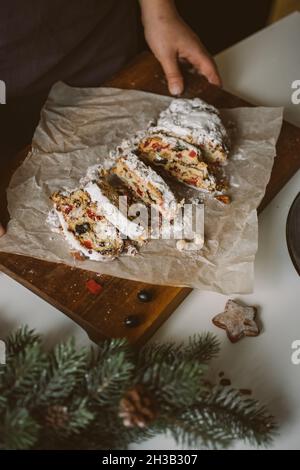 Baker serviert Weihnachtsgebäck, Stollen auf Holzbrett. Stockfoto