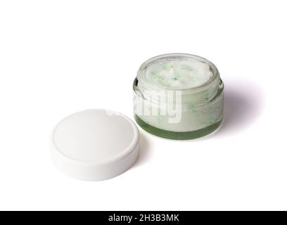 Kosmetisches Peeling mit Textur für Gesicht und Körper im Glasgefäß mit weißer Kappe. Körperpeeling mit grünen Kristallen. Isoliert auf weißem Hintergrund. Stockfoto