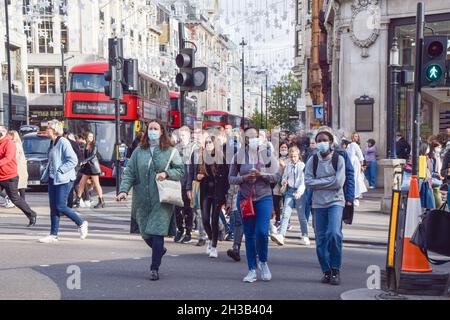 Menschen, die während der Coronavirus-Pandemie auf einer belebten Oxford Street Schutzmasken tragen. London, Großbritannien, 26. Oktober 2021. Stockfoto