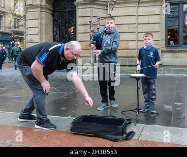 Glasgow, Großbritannien. Oktober 2021. CALUM PEARSON im Alter von 13 Jahren (Pfeifer) und sein Bruder DANIEL PEARSON im Alter von 9 Jahren (Schlagzeuger) aus Aberdeen besuchten Glasgow mit ihren (anwesenden) Eltern und buschten im Urlaub in der Buchanan Street im Stadtzentrum, um ihr Urlaubsgeld zu erhöhen. Sowohl Calum als auch Daniel sind Mitglieder der Buckburn und der District Pipe Band aus Aberdeen. Calum spielt seit 4 Jahren Dudelsack und Daniel trommelt seit 2 Jahren. Kredit: Findlay/Alamy Live Nachrichten Stockfoto