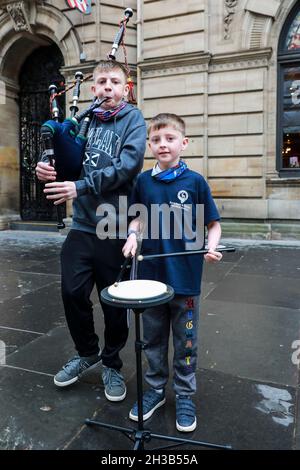 Glasgow, Großbritannien. Oktober 2021. CALUM PEARSON im Alter von 13 Jahren (Pfeifer) und sein Bruder DANIEL PEARSON im Alter von 9 Jahren (Schlagzeuger) aus Aberdeen besuchten Glasgow mit ihren (anwesenden) Eltern und buschten im Urlaub in der Buchanan Street im Stadtzentrum, um ihr Urlaubsgeld zu erhöhen. Sowohl Calum als auch Daniel sind Mitglieder der Buckburn und der District Pipe Band aus Aberdeen. Calum spielt seit 4 Jahren Dudelsack und Daniel trommelt seit 2 Jahren. Kredit: Findlay/Alamy Live Nachrichten Stockfoto