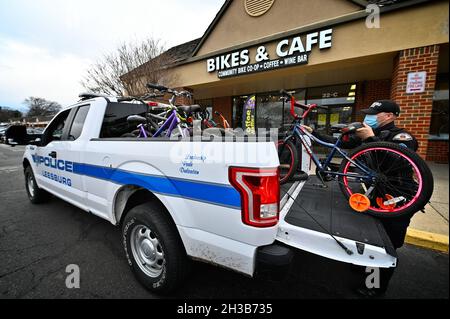 VEREINIGTE STAATEN - 01-08-21: Der Polizeibeamte J. Carter von Leesburg entlädt eine LKW-Ladung von Fahrrädern zur Spende an Maverick Charities. Das gespendete Fahrrad wird Stockfoto