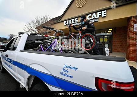 VEREINIGTE STAATEN - 01-08-21: Der Polizeibeamte J. Carter von Leesburg entlädt eine LKW-Ladung von Fahrrädern zur Spende an Maverick Charities. Das gespendete Fahrrad wird Stockfoto