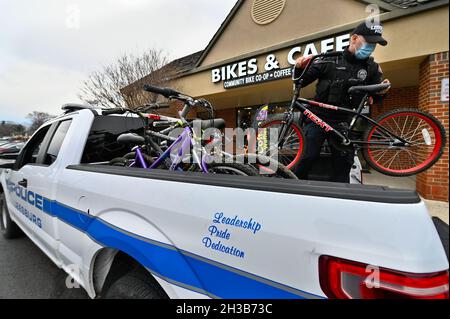 VEREINIGTE STAATEN - 01-08-21: Der Polizeibeamte J. Carter von Leesburg entlädt eine LKW-Ladung von Fahrrädern zur Spende an Maverick Charities. Das gespendete Fahrrad wird Stockfoto