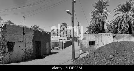 Kahartum, Sudan, ca. 5. Februar 2019: Dorf mit Schlammhütten und Stromleitungen und einzelnen Palmen in der Nähe der Hauptstadt Stockfoto