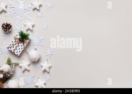 Komposition zum neuen Jahr. Weihnachtsgeschenk Tannenzapfen Zweige Schneeflocken und Sterne auf einem hellgrauen Hintergrund. Draufsicht: Platz für flache, layierte Kopien. Stockfoto