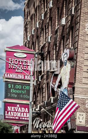 6-2-2021 Nevada USA - Hotel Nevada und Gambling Hall mit Neon Zeichen Cowboy mit Pickax und American flag.jpg Stockfoto