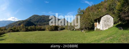 Ein Panoramablick auf eine Berglandschaft in den Julischen Alpen mit einem Steinhaus und Wanderweg Stockfoto