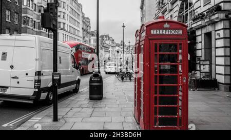 Selektive Farbaufnahme einer Bus- und Telefonzelle in einer Graustufe von Kingston upon Thames, Großbritannien Stockfoto