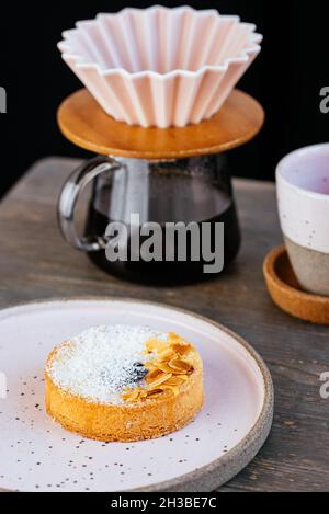 Kaffeekocher mit Kaffee auf dem Tisch und Dessert Stockfoto