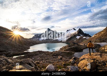 Junger Mann mit Blick auf den hohen Sonnenaufgang in Selkirks Stockfoto