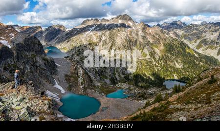 Ältere Wanderer blicken auf die Berge mit Seen in Selkirks Stockfoto