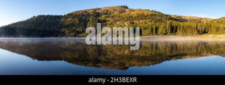 Panorama des Bergrückens und perfekte Reflexion im See bei Sonnenaufgang Stockfoto