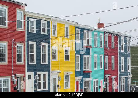 St. John's, NL, Kanada-Oktober 2021: Mehrere bunte Holzhäuser, auf einer Straße mit einem leichten Hügel. Es gibt Dachgauben und Hüftdächer. Stockfoto