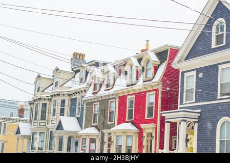 St. John's, NL, Kanada-Oktober 2021: Mehrere bunte Holzhäuser, auf einer Straße mit einem leichten Hügel. Es gibt Dachgauben und Hüftdächer. Stockfoto