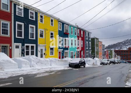 St. John's, NL, Kanada-Oktober 2021: Mehrere bunte Holzhäuser, auf einer Straße mit einem leichten Hügel. Es gibt Dachgauben und Hüftdächer. Stockfoto
