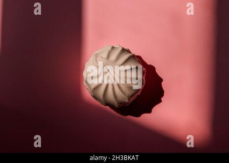 Eine weiße Marschmallow liegt auf einem rosa Hintergrund mit einem Platz für einen Einsatz. Stockfoto