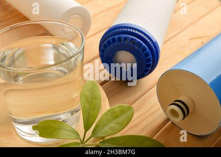 Glas gereinigtes Wasser mit heimischen umweltfreundlichen Filtern auf Holztisch. Erhöhte Ansicht. Horizontale Zusammensetzung. Stockfoto