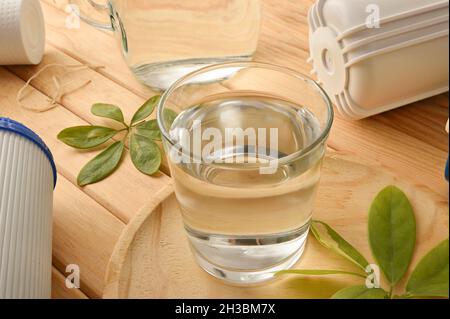 Glas gefiltertes Wasser mit Umkehrosmose-Anlage mit Filtern auf Holztisch. Erhöhte Ansicht. Horizontale Zusammensetzung. Stockfoto