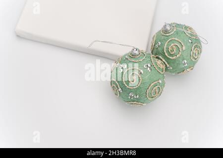 Weihnachtszeit grüne Silberkugeln und Leinwand auf weißem Hintergrund Stockfoto